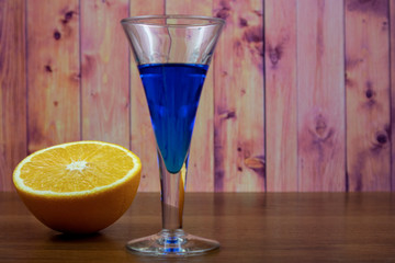 Blue Curacao liqueur in shot glass with orange