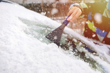 Scraping ice from the car window