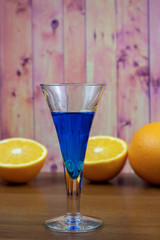 Blue Curacao liqueur in shot glass with orange