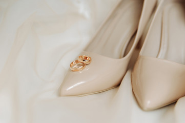 Bridal shoes and wedding rings.