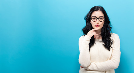 Young woman in a thoughtful pose on a solid background