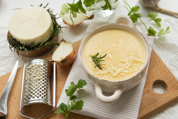 Cheese soup with yellow and white cheese, cream, onions and potatoes