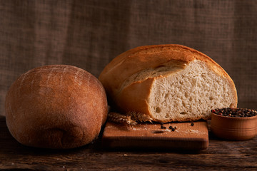 Different bread and wheat on the rustic table. Selective focus, close up