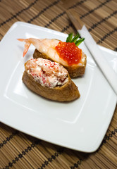 Omelette sushi with rice and salad with salmon, shrimps and caviar