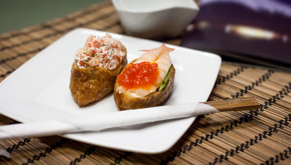 Omelette sushi with rice and salad with salmon, shrimps and caviar