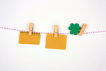 old vintage paper mock up and shamrock paper cut leaves on clothespin on white bakground