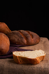 Different bread and wheat on the rustic table. Selective focus, close up