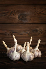 a lot of farm fresh garlic on a wooden background