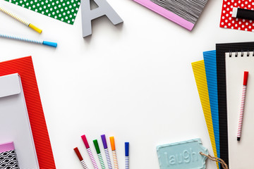 Creative colorful desk with school supplies. Notebooks, markers, colorful papers. Copy space for text