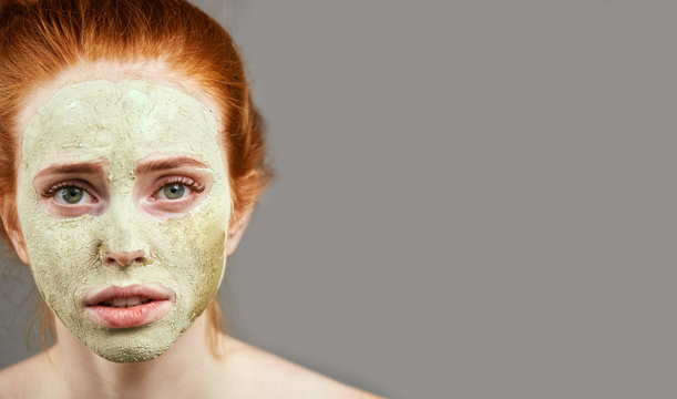 serios girl with clay mask. close up cropped photo. copy space . carbonated clay mask for face for young skin