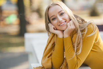 Closeup portrait of young attractive woman outdoors with copy space. Beautiful blond girl model. Cheerful lady on neutral background spring, fall, autumn. - obrazy, fototapety, plakaty