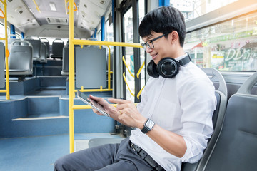 Passenger transport. people in the bus. man rides a bus, listening or calling to music and typing a message while riding home.
