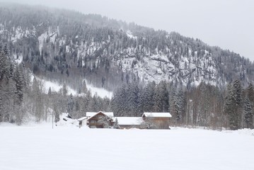 Haus im Schnee in Oberstdorf vor schneebedeckten Bergen