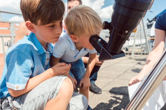Young boy looking thru sun refractor in public star observatory