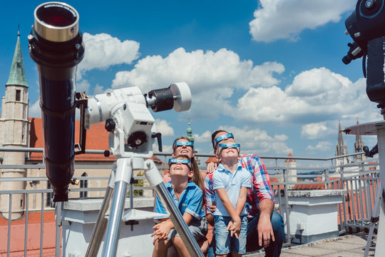 Family watching a solar eclipse in historic star observatory