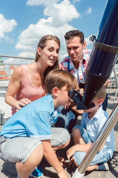 Family learning about science in star observatory looking at sun 
