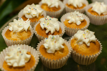 Bakery. Stock of Muffins covered with cream.