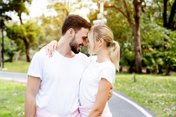 Naklejka premium Caucasian Couples, men and women standing facing the nose, colliding And hugging in the garden In good weather in the morning of summer With fresh breath from good oral health care