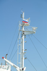 Mast of a large white motor ship in the sea with the flag of Russia.