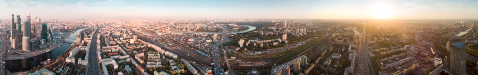 Fototapeta premium panorama high-rise buildings and transport of metropolis, traffic and blurry lights of cars on multi-lane highways and road junction at sunset in Moscow.