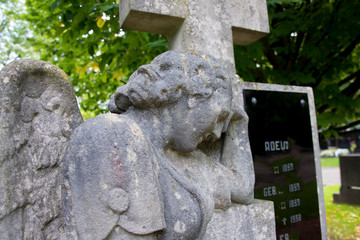 Ein Engel lehnt an einem Steinkreuz