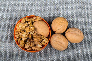whole walnuts and kernels on burlap background, healthy food