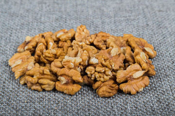 whole walnuts and kernels on burlap background, healthy food