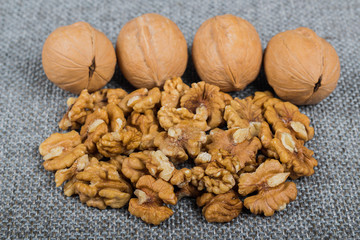 whole walnuts and kernels on burlap background, healthy food
