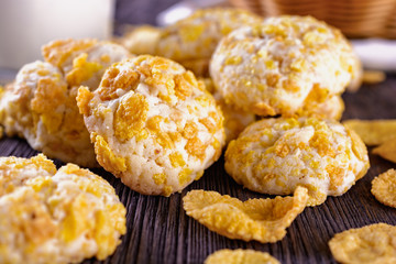 Tasty and beautiful cornflakes cookies and a glass of milk on a wooden table, macro