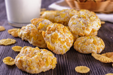 Tasty and beautiful cornflakes cookies and a glass of milk on a wooden table