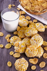 Tasty and beautiful cornflakes cookies and a glass of milk on a wooden table, vertical orientation