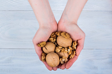 Woman holding whole walnut in her hands. Walnut isolated. Walnut, healthy organic food concept. Top view. View above