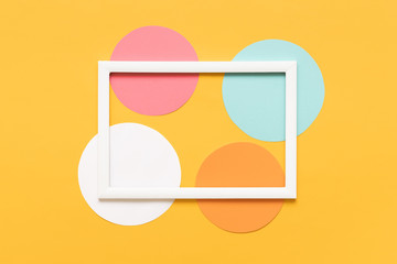 Fototapeta na wymiar Abstract geometrical yellow, pastel blue and pink paper flat lay background. Minimalism, geometry and symmetry template with empty picture frame mock up.