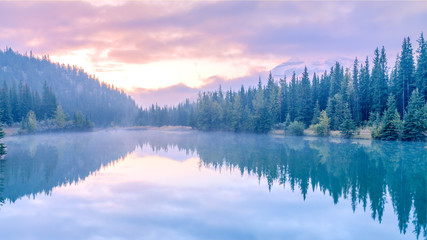 Fototapeta na wymiar Water reflection of Cascade lake with morning mist and sunrise , Banff National park