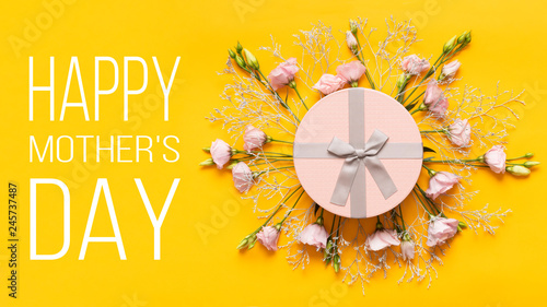 Happy Mother's Day Background. Bright Yellow and Pastel Pink Colored Mother Day Background. Flat lay greeting card with beautiful gift box and pink lisianthus flowers.