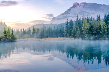 Golden yellow sky of morning sunrise with water refelction of Cascade pond in Banff National park - obrazy, fototapety, plakaty