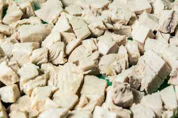 Diced boiled chicken meat on a green board