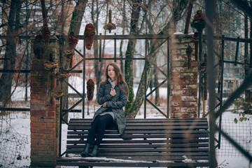 Obraz na płótnie Canvas A young woman walks in a winter park.