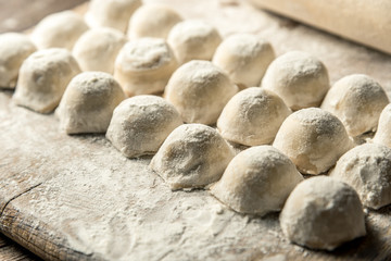 Uzbek national food Chuchvara, like dumplings, on a wooden board, in flour