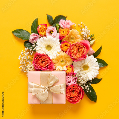 Happy Mother's Day, Women's Day, Valentine's Day or Birthday Pastel Candy Colors Background. Floral flat lay greeting card with beautifuly wrapped present and copy space.