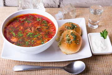 Borscht/borsch. Traditional Russian and Ukrainian soup. Buns with garlic. Close-up, selective focus.