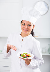 Brunette girl chef  and plate with salad