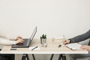 People working on a desk in small business office, side view