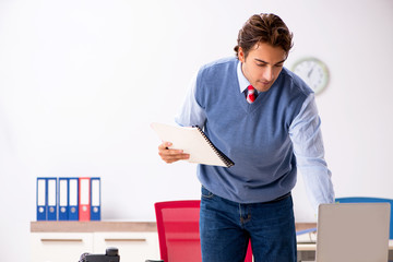 Young handsome employee working in the office 