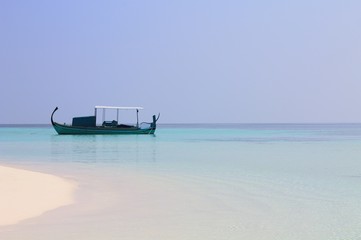 Isolated traditional maldivian boat called "Dhoni" (Ari Atoll, Maldives)