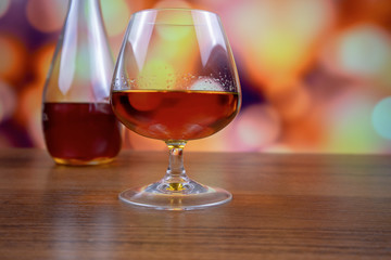 Glass of cognac (brandy) and a bottle in the background