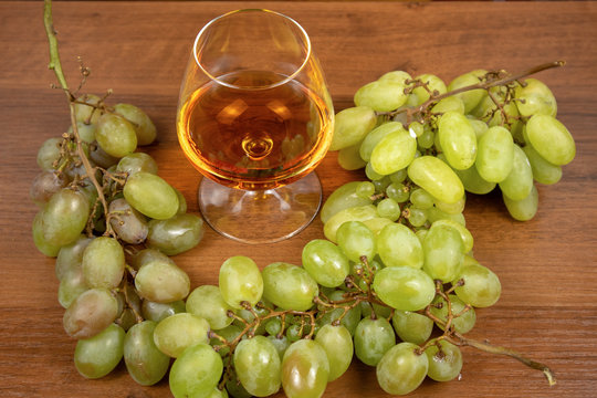 Cognac in a glass and berries of white grapes
