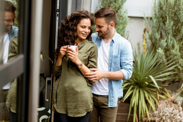 Fototapeta premium Happy cute couple in love embracing each other and drinking coffee