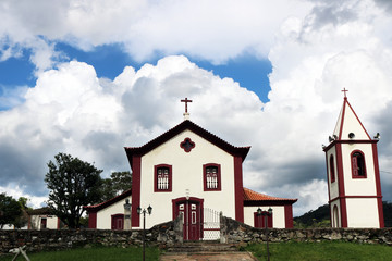 Little colonial church against blue cloudy sky