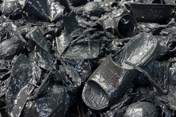 Plastic and other rubbish including discarded slipper in polluted muddy water